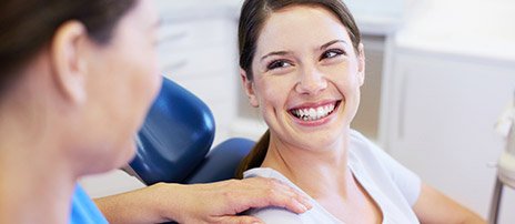 Happy woman in dental chair smiling jovially