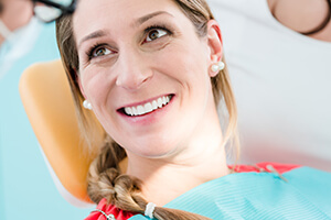 lady in dental chair smiling with picture-perfect teeth