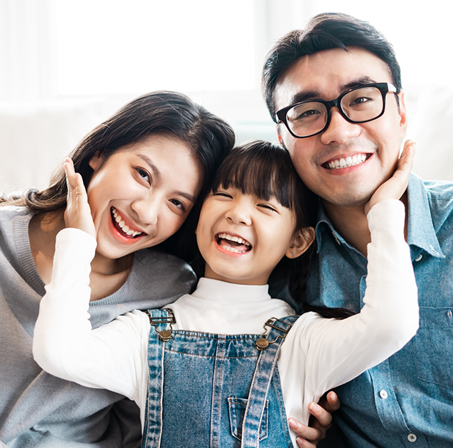 Family of three smiling after seeing their Aetna dentist in Sparks