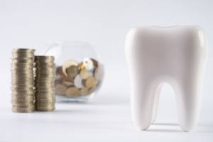 Tooth next to a pile of coins