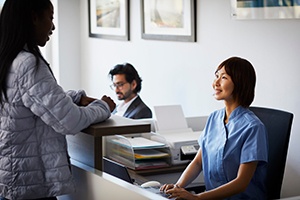 front desk office staff speaking with a patient