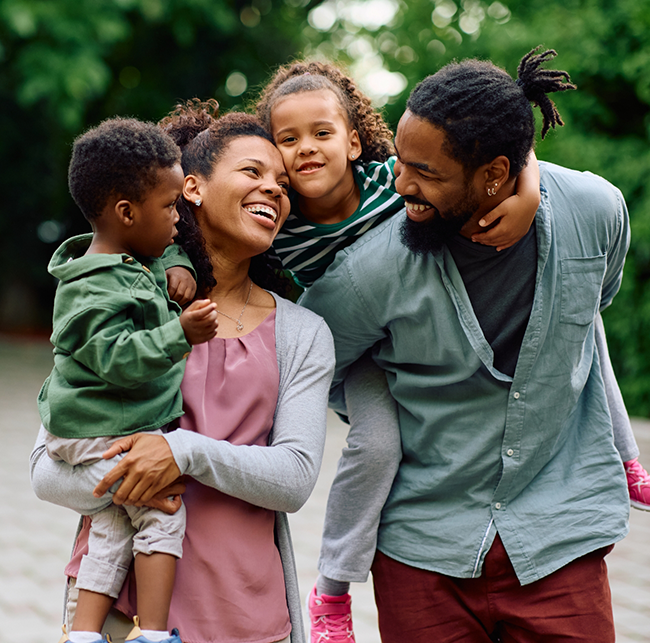 Family of four smiling after visiting their dentist in Sparks