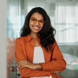 Woman in orange suit smiling with arms folded