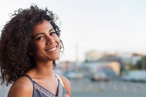 Woman standing outside in parking lot and smiling