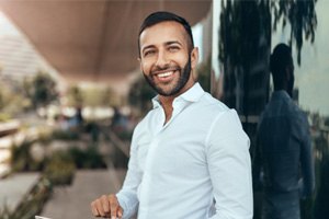 Man standing next to a building and smiling