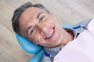 Man leaning back in dental chair and smiling