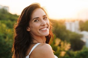 Woman standing outside, looking back, and smiling