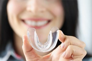 Close-up of woman holding a mouthguard