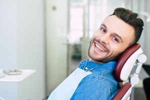 Man in dental chair looking to side and smiling