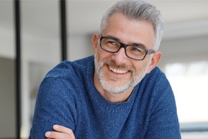 Man in blue shirt leaning forward and smiling