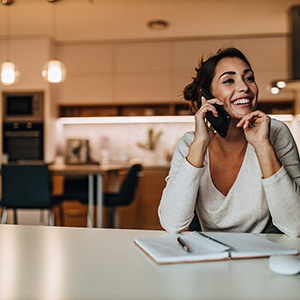 Woman smiling while talking on phone at home