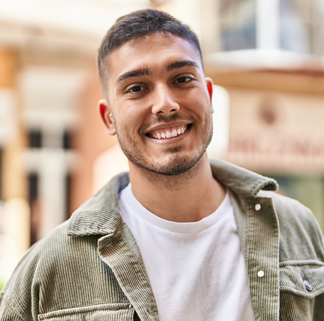 Young man in a light green jacket smiling