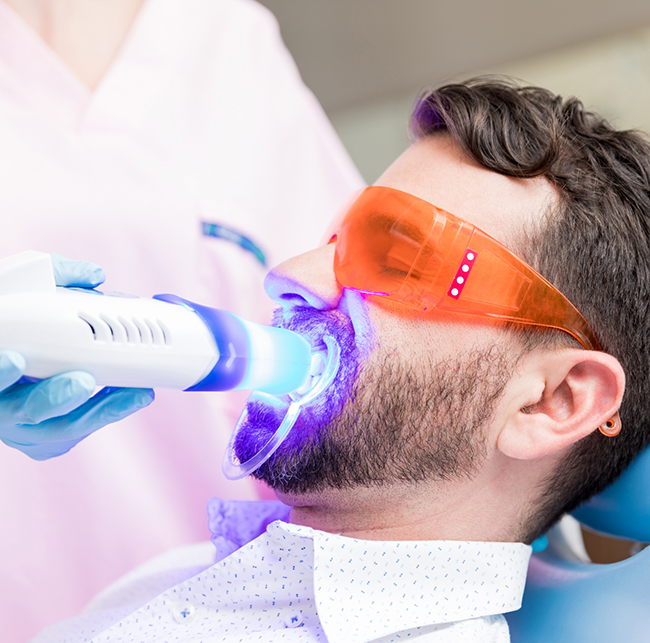 Man in the dental chair getting professional teeth whitening in Sparks