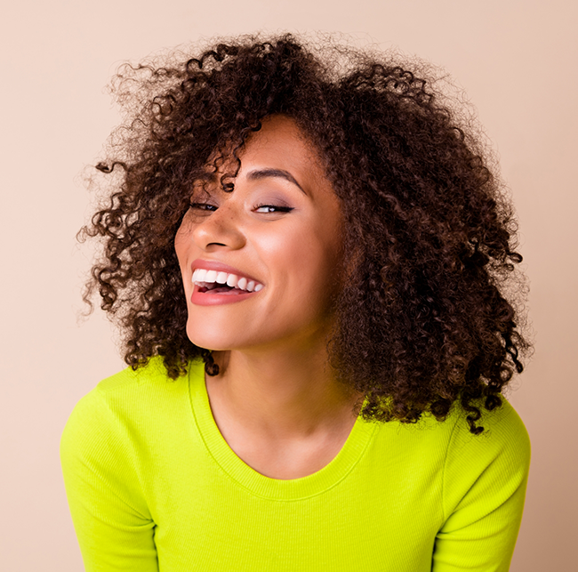 Woman in a yellow blouse smiling with veneers in Sparks