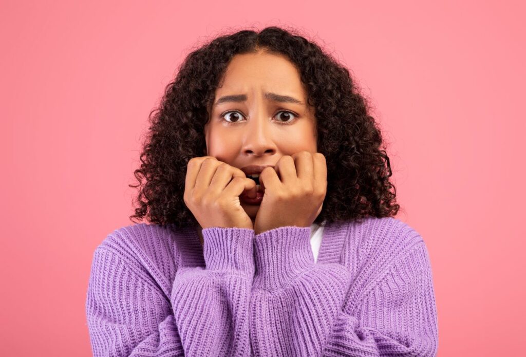  A woman biting her fingernails.